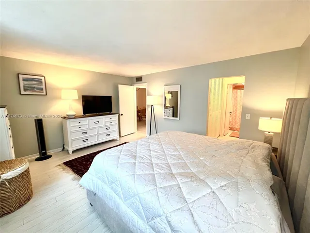 a large bedroom with a bed and a flat screen tv