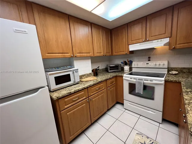 a kitchen with cabinets appliances and a sink