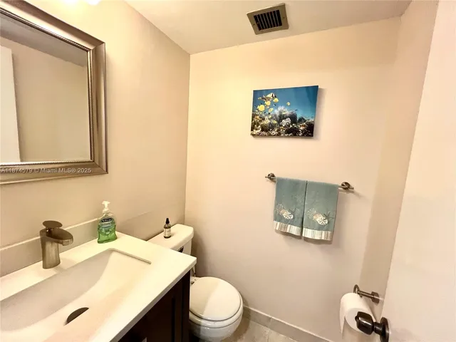 a bathroom with a sink mirror and toilet