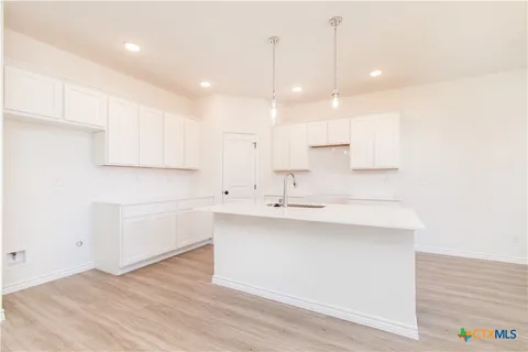 a kitchen with kitchen island a sink stainless steel appliances and cabinets