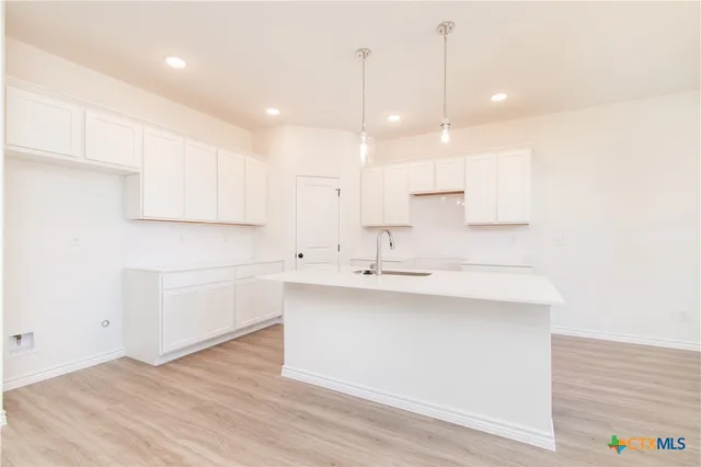 a kitchen with kitchen island a sink stainless steel appliances and cabinets
