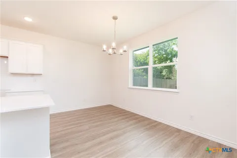 a view of a room with wooden floor and windows