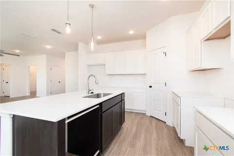 a kitchen with a sink a stove and cabinets