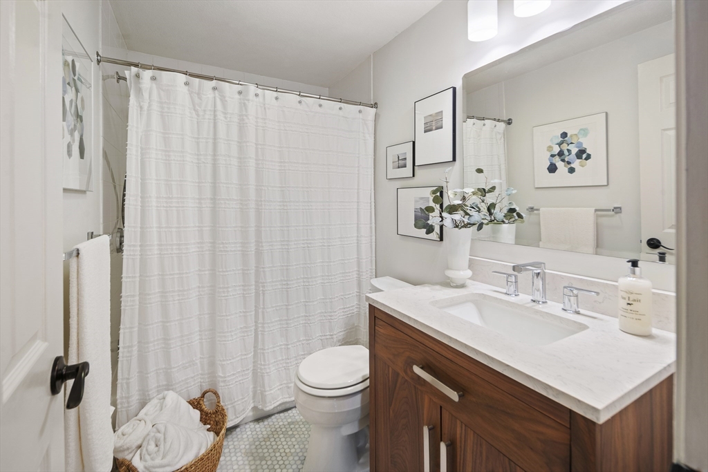 120 Medford Street, Unit 120 Arlington, MA 02474 - Photo 10 of 25 a bathroom with a sink vanity mirror and toilet