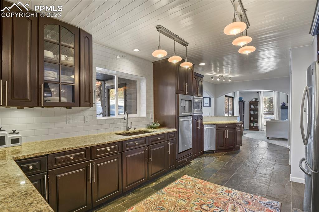 450 Jack Boot Road Monument, CO 80132 - Photo 12 of 45 a kitchen with a sink dishwasher and a stove with wooden floor