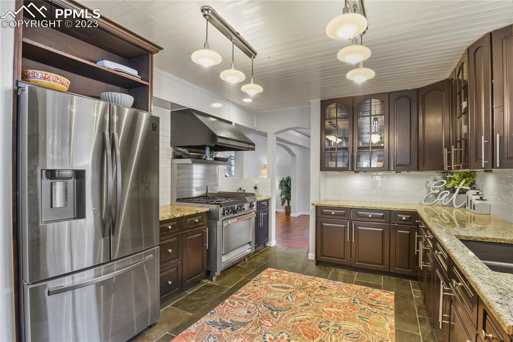 450 Jack Boot Road Monument, CO 80132 - Photo 13 of 45 a kitchen with stainless steel appliances granite countertop a sink stove and refrigerator