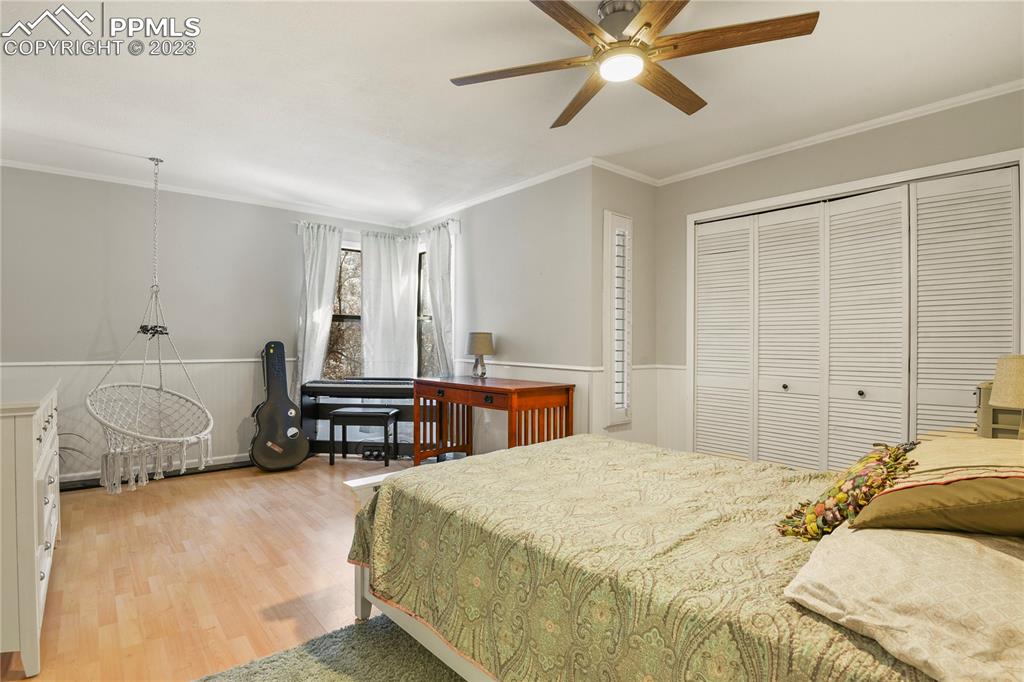 450 Jack Boot Road Monument, CO 80132 - Photo 26 of 45 a bedroom with a bed and a chandelier