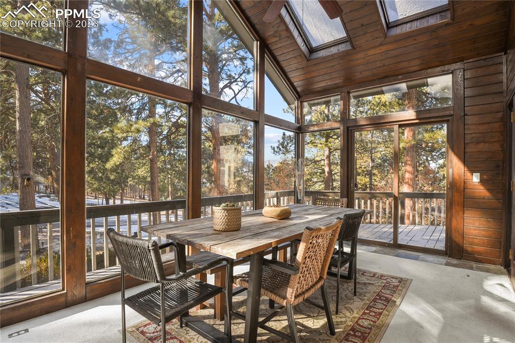 450 Jack Boot Road Monument, CO 80132 - Photo 8 of 45 a view of a dining room with furniture large windows and wooden floor