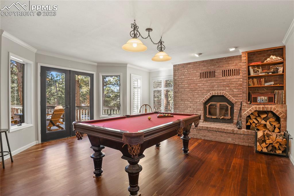 450 Jack Boot Road Monument, CO 80132 - Photo 10 of 45 a living room with a pool table and wooden floor