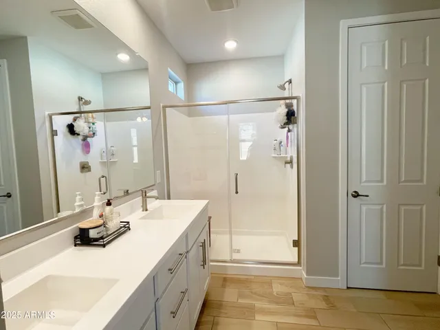 a bathroom with a double vanity sink mirror and shower