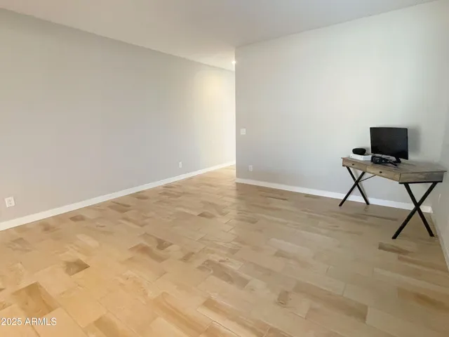 a view of workspace with wooden floor and a window