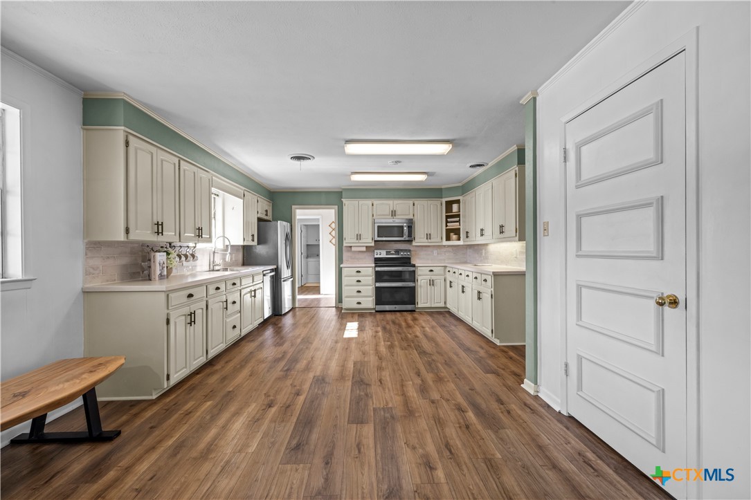 2601 Linwood Road Temple, TX 76502 - Photo 13 of 41 a kitchen with stainless steel appliances a sink cabinets and wooden floor