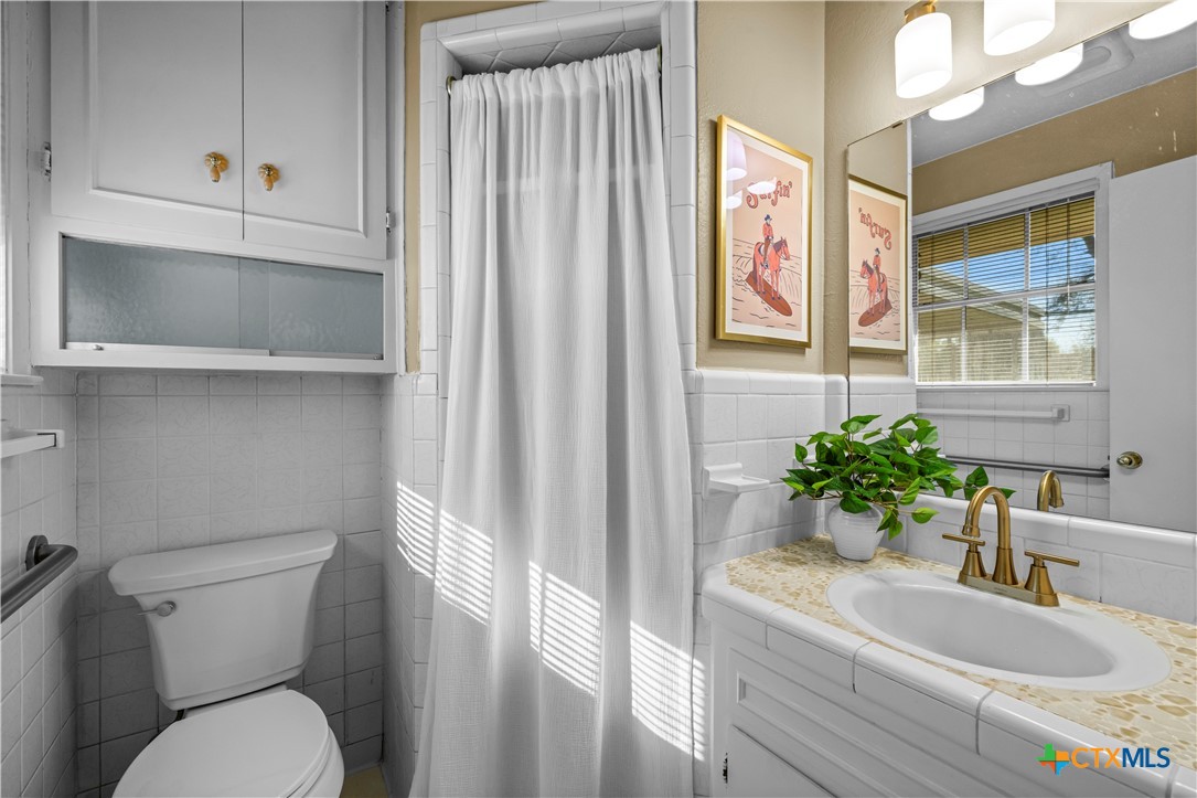 2601 Linwood Road Temple, TX 76502 - Photo 26 of 41 a bathroom with a granite countertop sink a mirror and a toilet