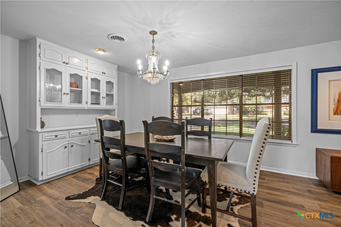 2601 Linwood Road Temple, TX 76502 - Photo 7 of 41 a view of a dining room with furniture a chandelier and wooden floor