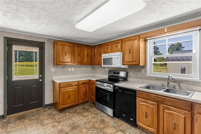 a kitchen with stainless steel appliances granite countertop sink stove and granite counter top
