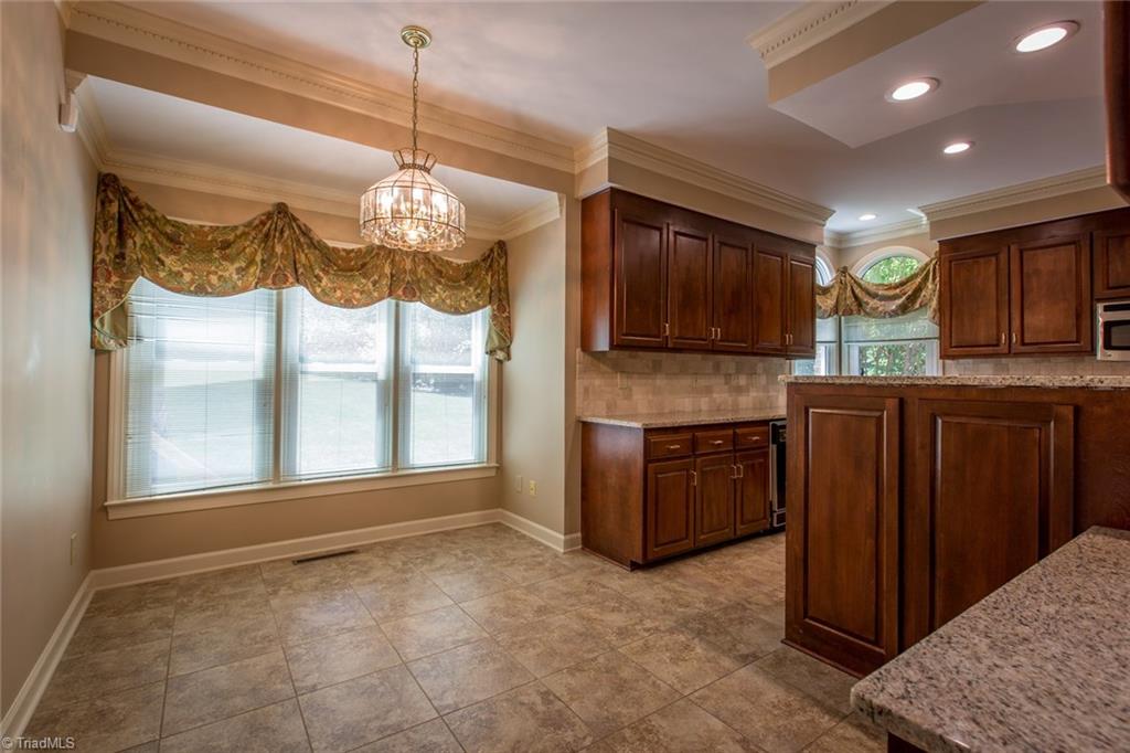 1170 Chester Road Winston-Salem, NC 27104 - Photo 17 of 30 Breakfast area with a wall of windows for natural light. There is a desk area and wine rack on the wall to the right.