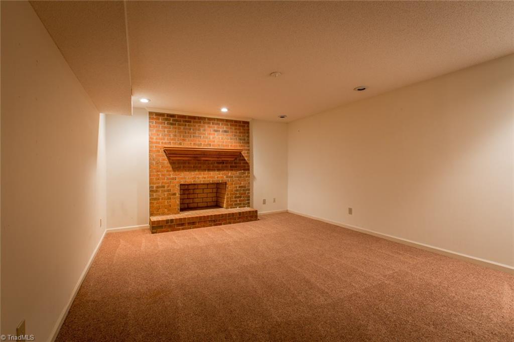 1170 Chester Road Winston-Salem, NC 27104 - Photo 25 of 30 Lower level Den with masonry fireplace, neutral dcor and recent carpet.