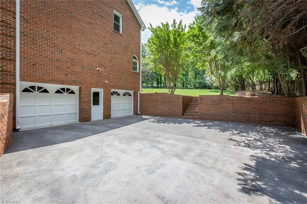 1170 Chester Road Winston-Salem, NC 27104 - Photo 30 of 30 Nice level driveway for basketball. Steps ahead lead to the fantastic yard. 2 car garage with automatic doors and a walkout door for easy access.