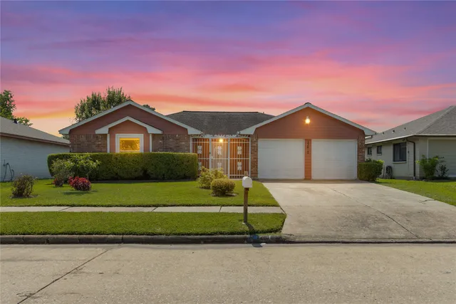 a front view of a house with a garden and yard