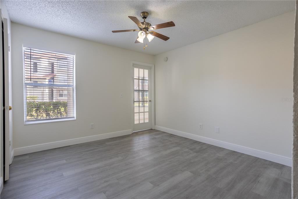 5156 Conroy Road, Unit 16 Orlando, FL 32811 - Photo 12 of 16 an empty room with wooden floor and windows