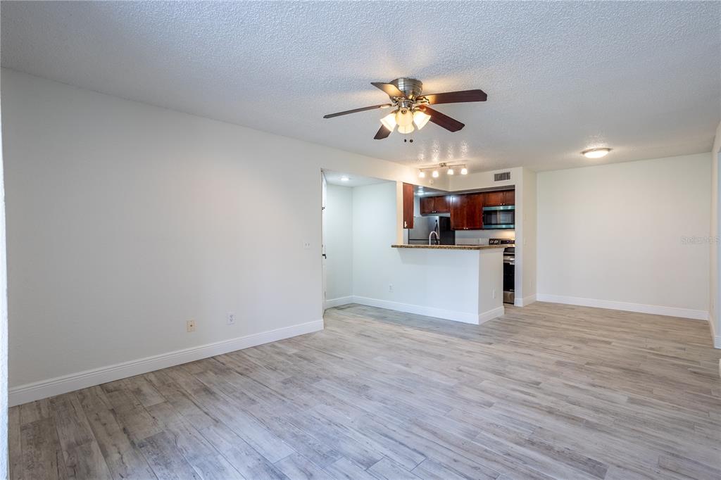 5156 Conroy Road, Unit 16 Orlando, FL 32811 - Photo 5 of 16 a view of a kitchen with a microwave and wooden floor