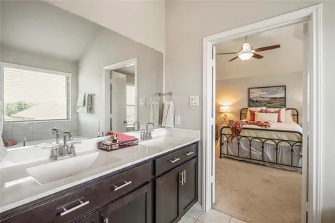 a en suite bathroom with a granite countertop sink and a mirror