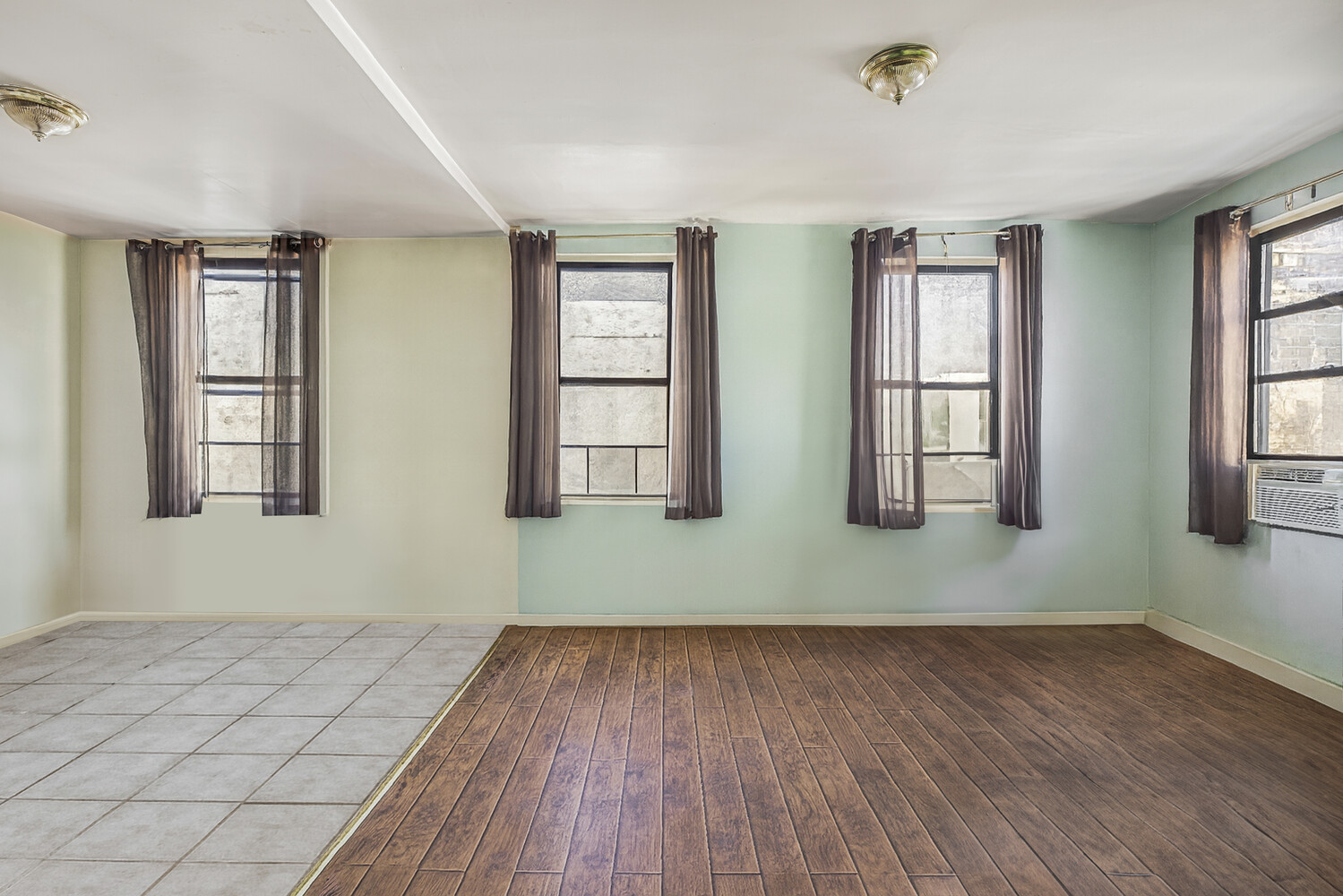 101 Graham Avenue, Unit MULTIFAMIL Brooklyn, NY 11206 - Photo 6 of 9 a view of empty room with wooden floor and fan