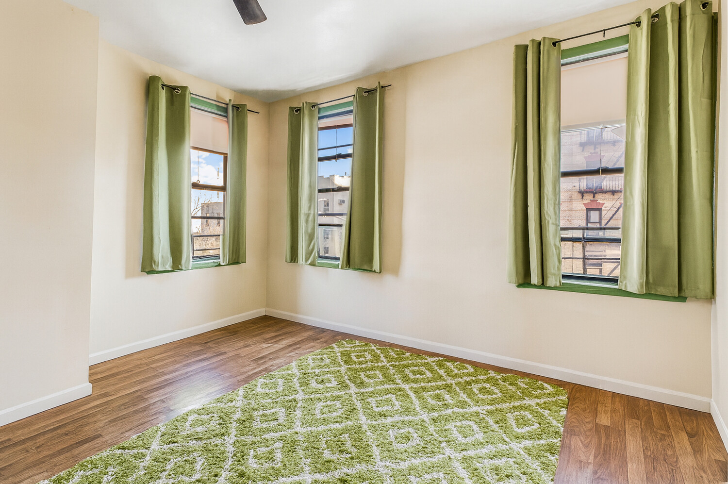 101 Graham Avenue, Unit MULTIFAMIL Brooklyn, NY 11206 - Photo 8 of 9 a view of an empty room with window and wooden floor