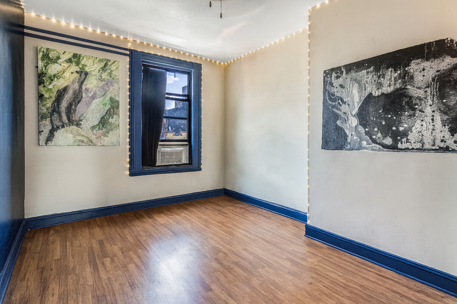101 Graham Avenue, Unit MULTIFAMIL Brooklyn, NY 11206 - Photo 9 of 9 an empty room with wooden floor and a window
