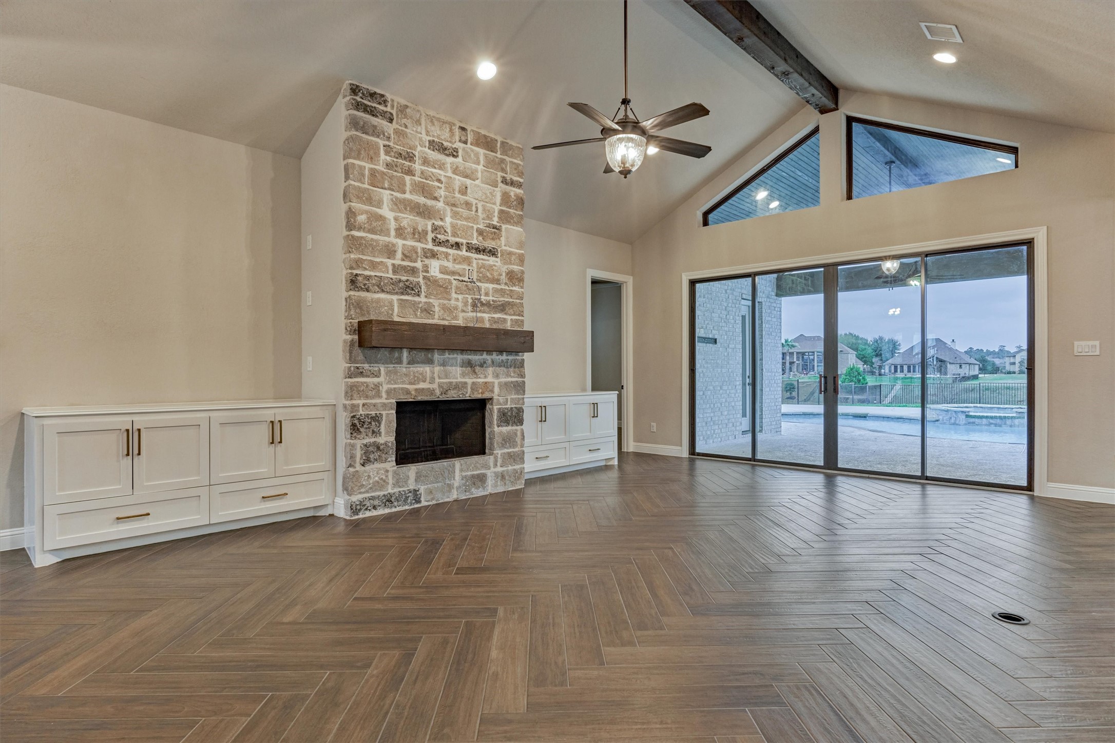 11618 Renaissance Drive Montgomery, TX 77356 - Photo 8 of 49 A floor to ceiling stone gas fireplace with wood mantle is flanked by stylish built-ins. The herringbone pattern tile continues throughout the first floor living space.