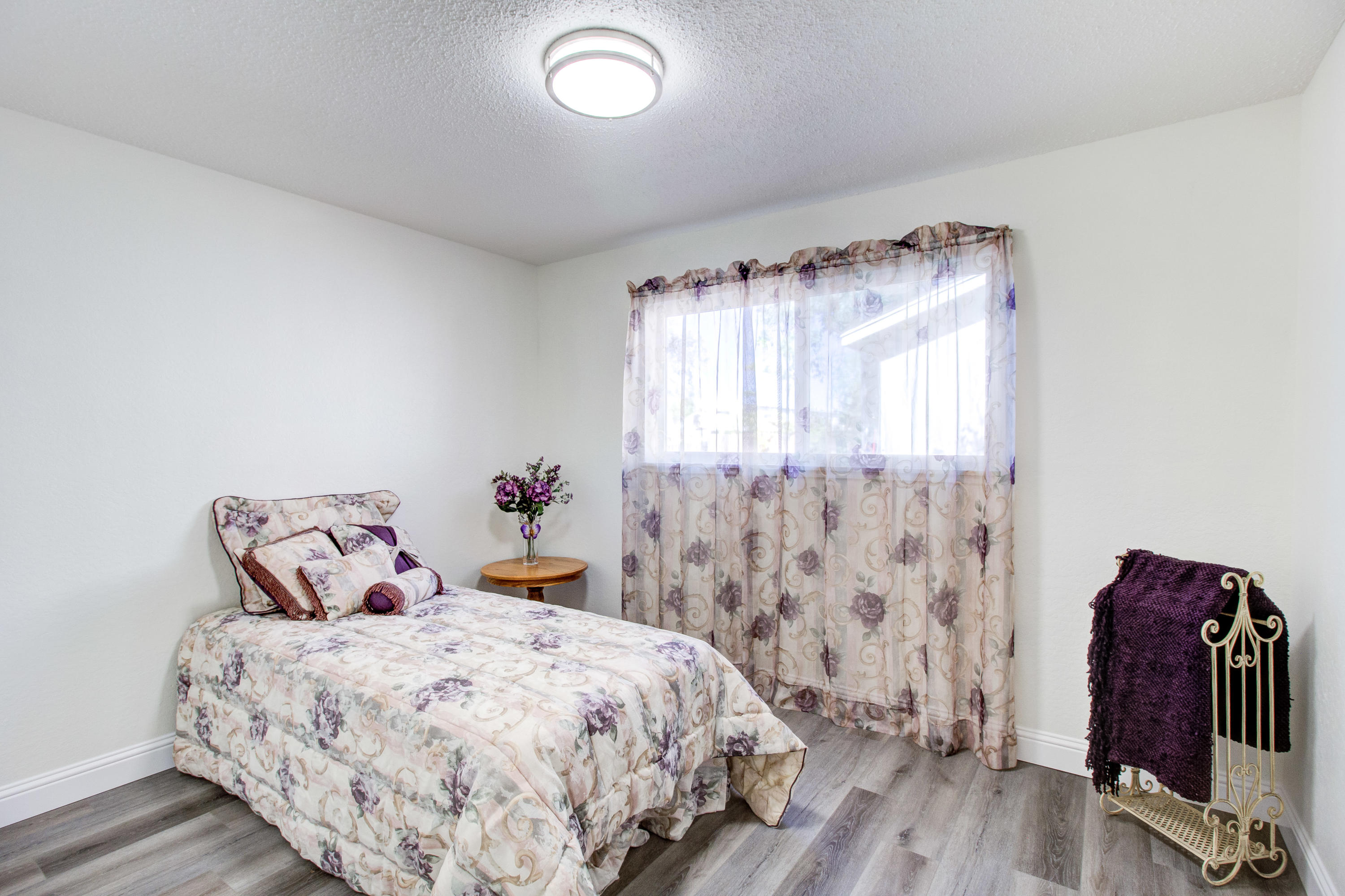 2602 Irwin Road Redding, CA 96002 - Photo 17 of 27 a bedroom with a bed and wooden floor