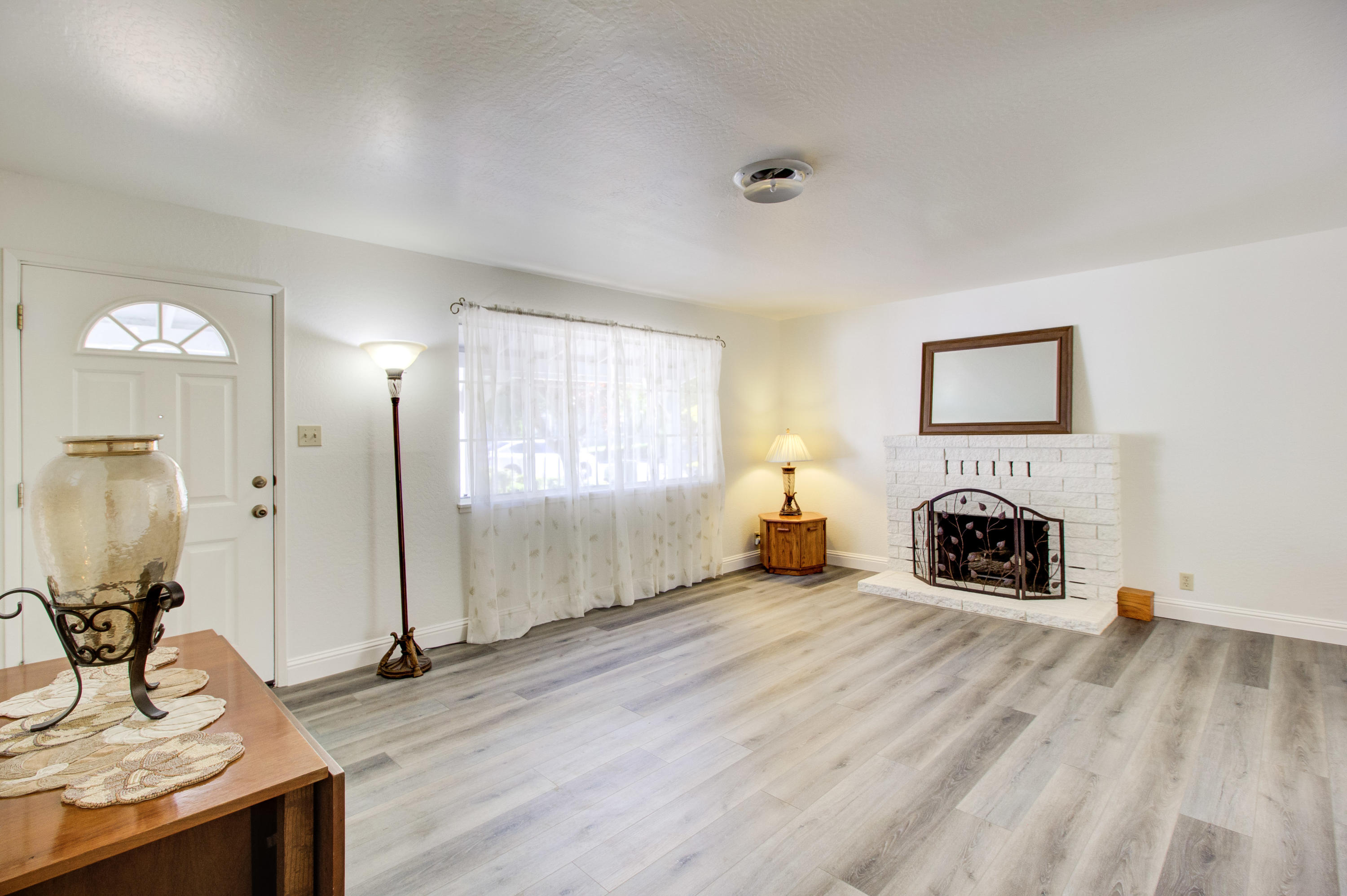 2602 Irwin Road Redding, CA 96002 - Photo 5 of 27 a view of a livingroom with a fireplace a window and wooden floor