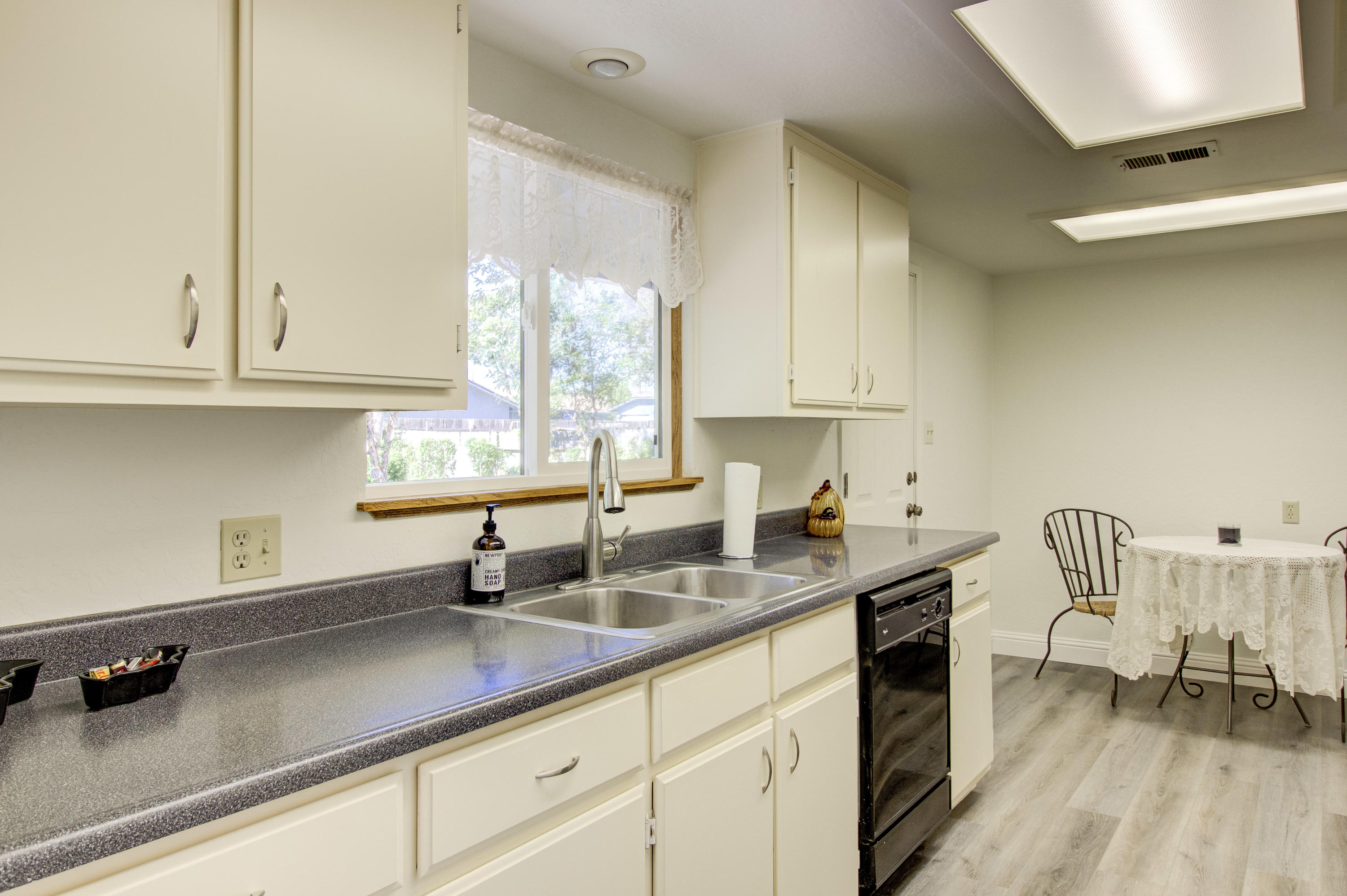 2602 Irwin Road Redding, CA 96002 - Photo 9 of 27 a kitchen with stainless steel appliances sink a window and white cabinets
