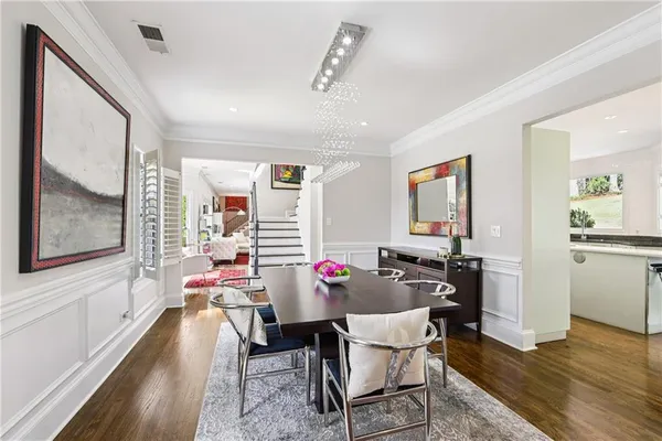 a bedroom with a bed and a dresser with wooden floor
