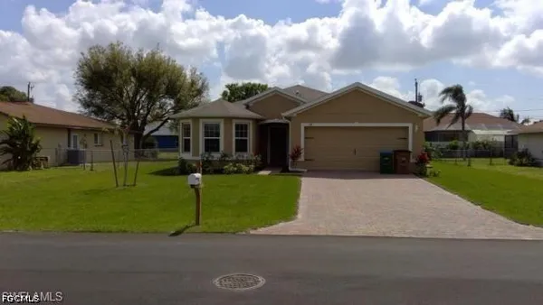 a front view of a house with a garden and yard