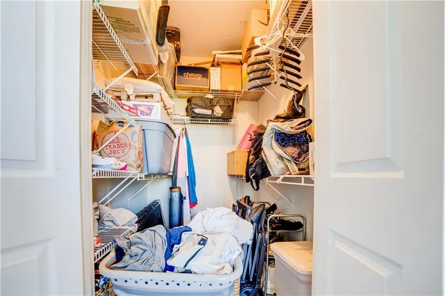 a view of walk in closet with clothes and shoes