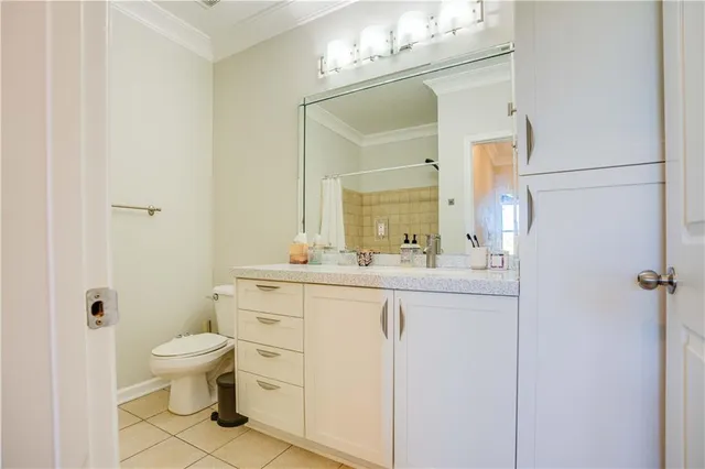 a bathroom with a toilet a sink a mirror a vanity and shower