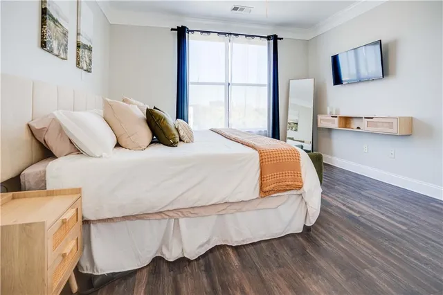 a bedroom with a bed and wooden floor