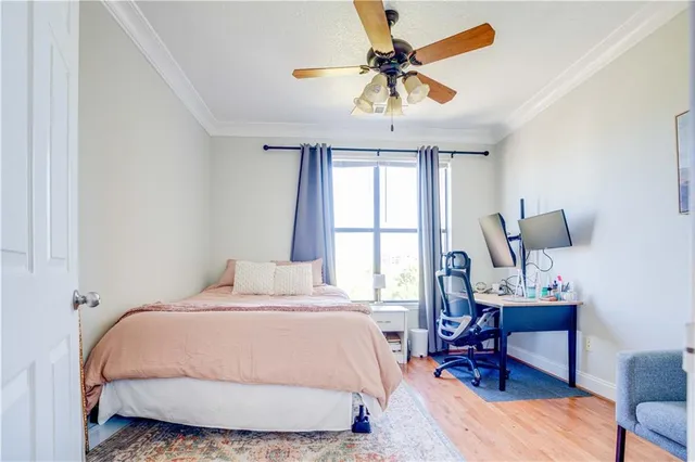 a bedroom with a bed a chair and a chandelier