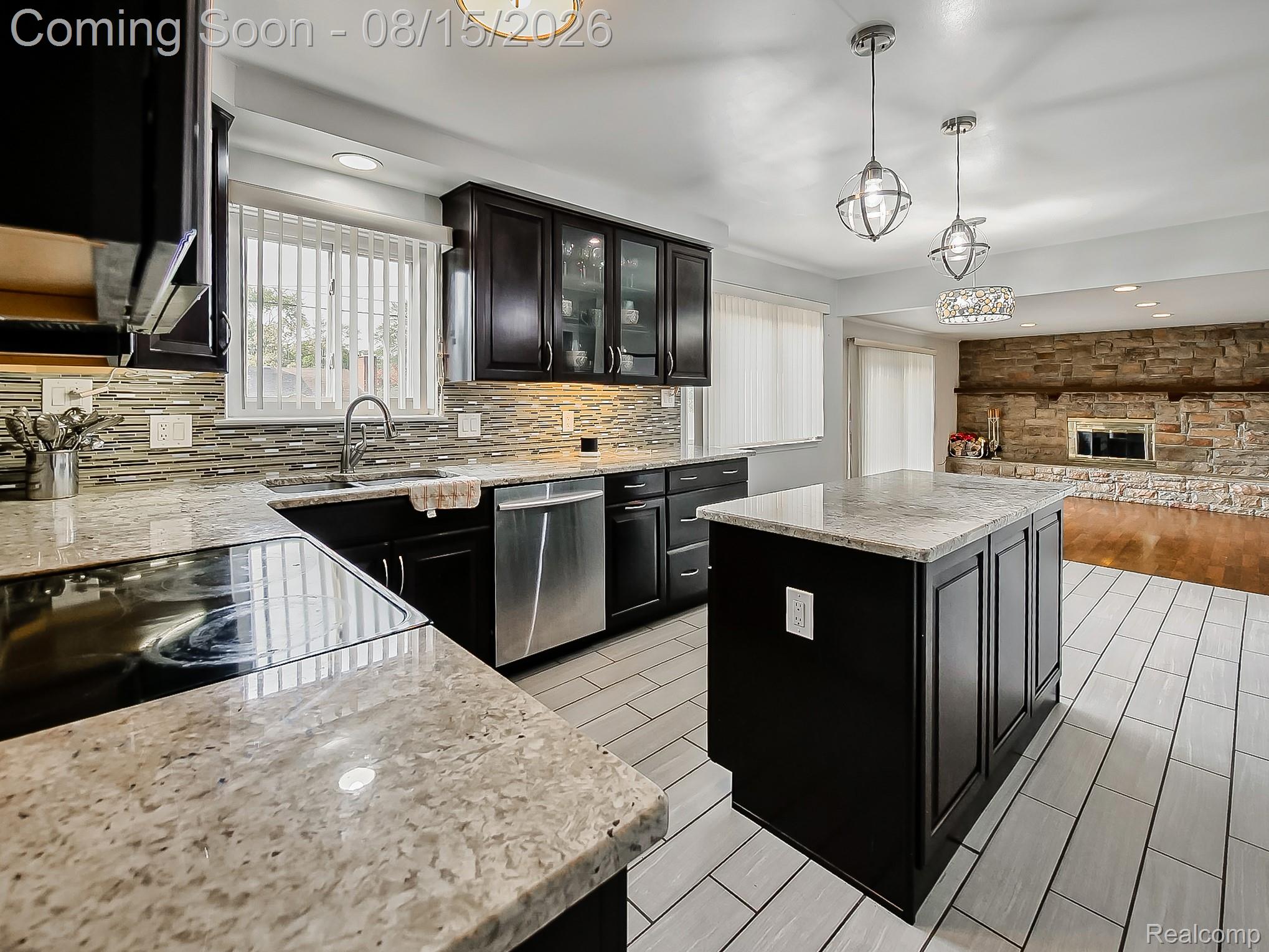 21131 Harvard Road Southfield, MI 48076 - Photo 5 of 33 Kitchen featuring dark wood-finish cabinetry, light-toned countertops, a central island, and stainless steel appliances