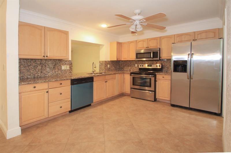 98 Seminole Lane Boca Raton, FL 33487 - Photo 5 of 42 a kitchen with stainless steel appliances granite countertop a stove a sink and a refrigerator