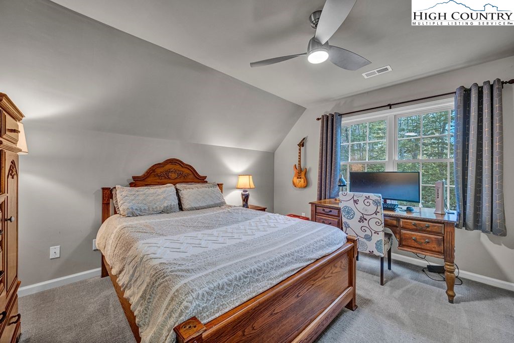 607 Charter Hills Road Beech Mountain, NC 28604 - Photo 12 of 31 a bedroom with a bed and a large window