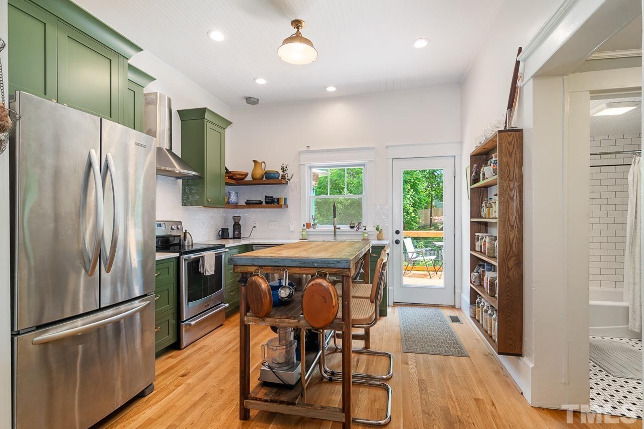 1808 Rosetta Drive Durham, NC 27701 - Photo 25 of 59 a kitchen with stainless steel appliances a dining table chairs refrigerator and microwave