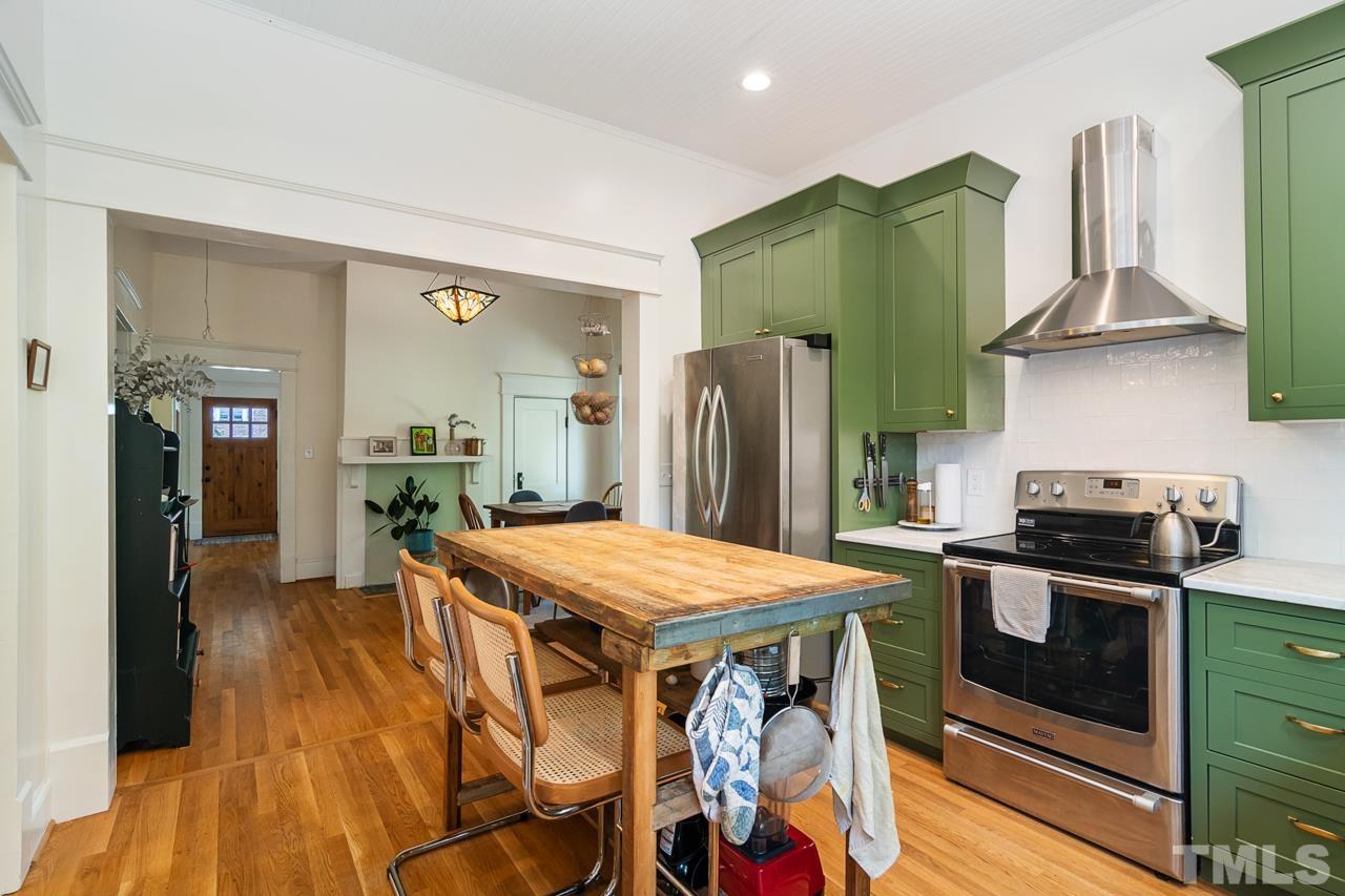 1808 Rosetta Drive Durham, NC 27701 - Photo 27 of 59 a kitchen with stainless steel appliances granite countertop a table chairs stove and refrigerator
