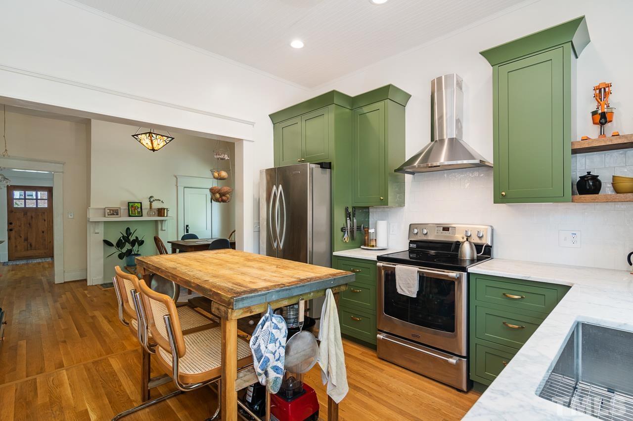 1808 Rosetta Drive Durham, NC 27701 - Photo 28 of 59 a kitchen with granite countertop a table chairs stove and refrigerator