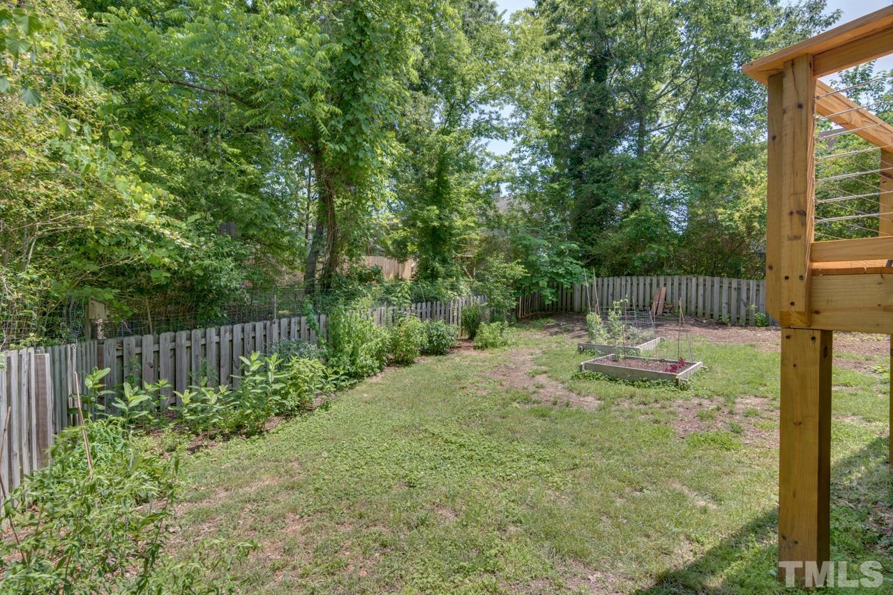 1808 Rosetta Drive Durham, NC 27701 - Photo 50 of 59 a backyard of a house with lots of plants and tree