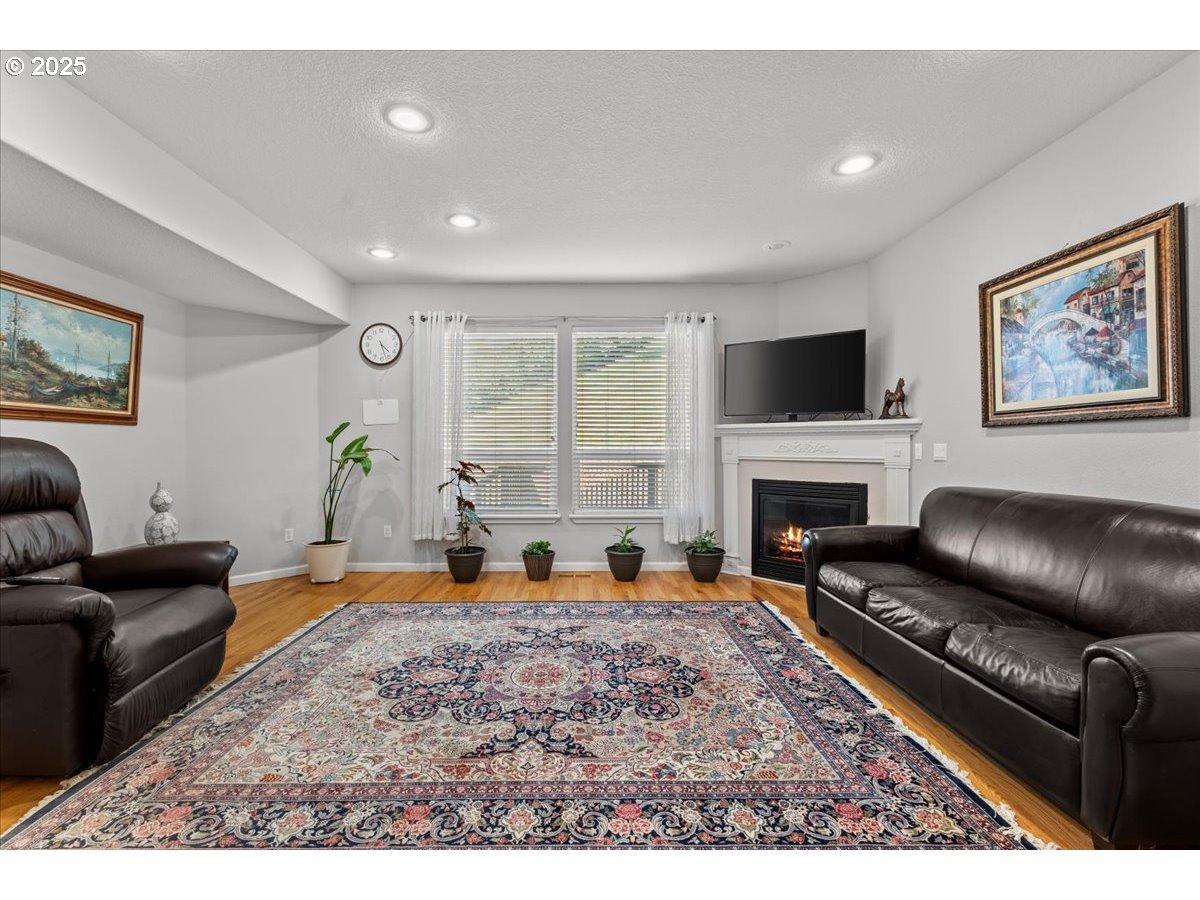5122 Southeast Jenne Road Portland, OR 97236 - Photo 28 of 36 a living room with furniture a fireplace and a flat screen tv