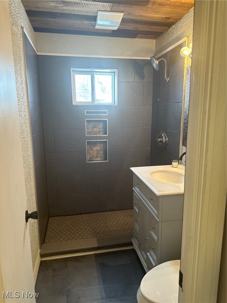12926 Littleton Road Garfield Heights, OH 44125 - Photo 9 of 12 Bathroom with tiled shower, toilet, wood ceiling, vanity, and tile patterned flooring