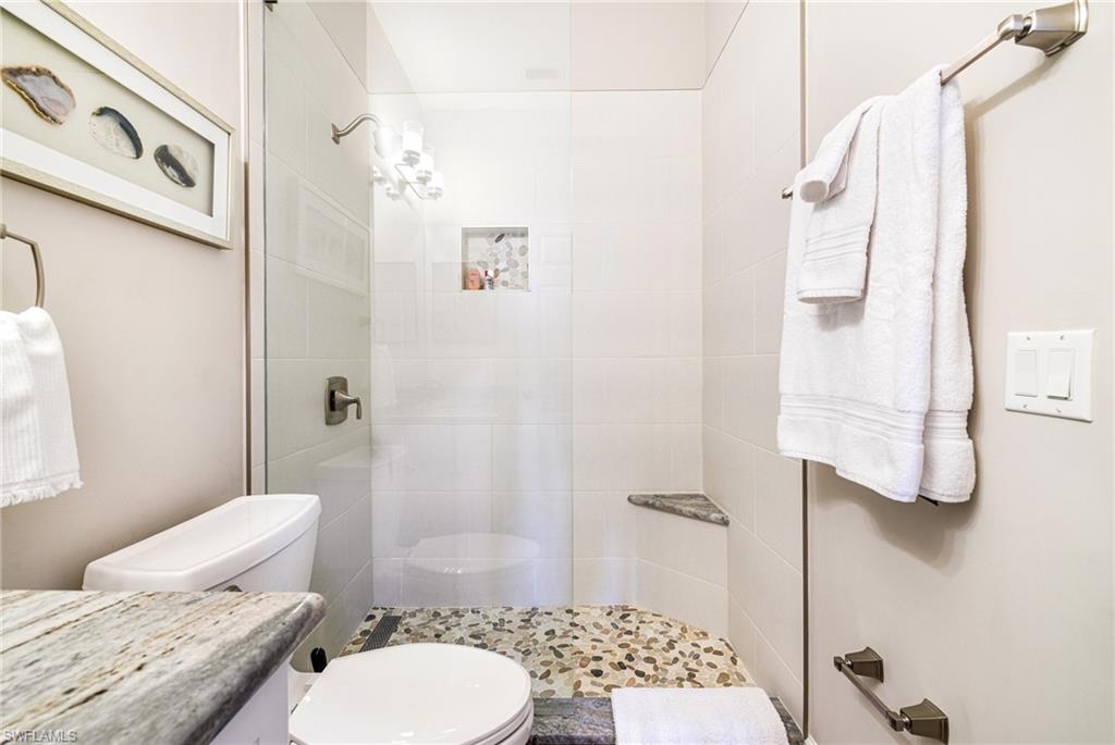 19081 Ridgepoint Drive, Unit 202 Estero, FL 33928 - Photo 15 of 50 a bathroom with a granite countertop toilet sink and shower
