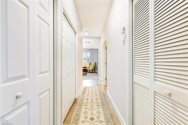 a view of a hallway with wooden floor and staircase